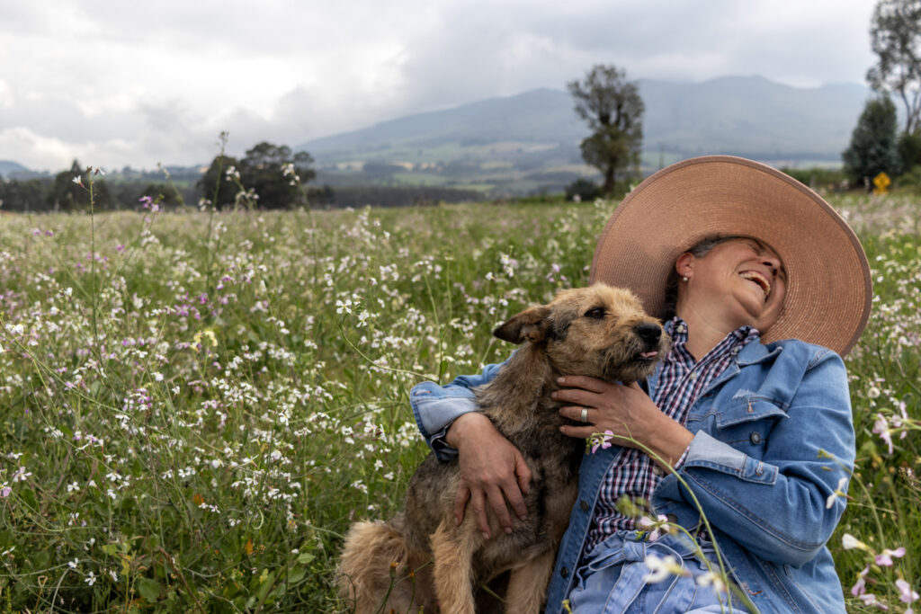 A person sitting in a field with a dog, active with your pet